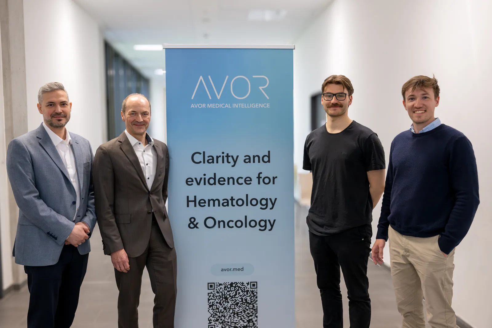 Vier Personen am AVOR-Roll-up-Banner während der Veranstaltung