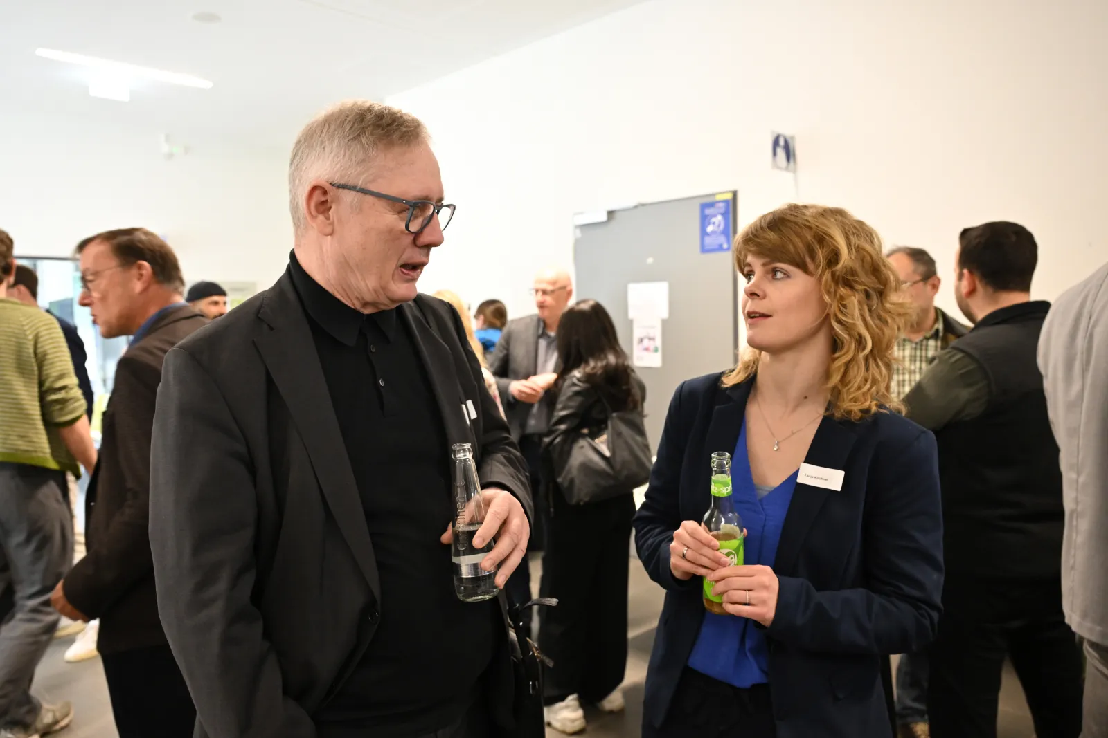 Gespräch zwischen Teilnehmenden mit Getränken im Foyer