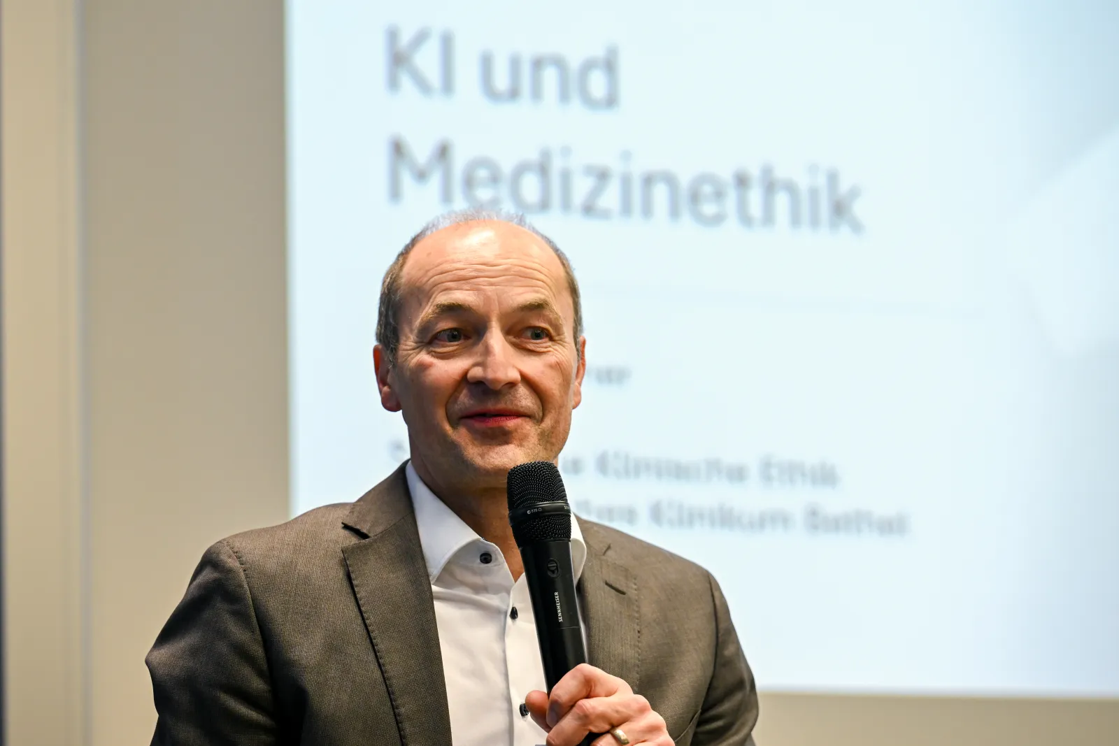 Tanja Kirchner mit Mikrofon zum Vortrag „KI und Medizinethik“